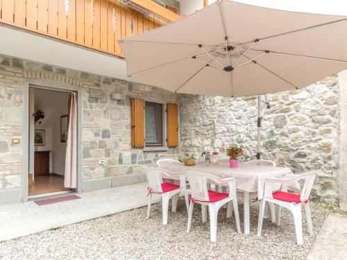 un tavolo bianco con sedie e ombrellone di Holiday Home Casa Tranquilla by Interhome a San Leonardo