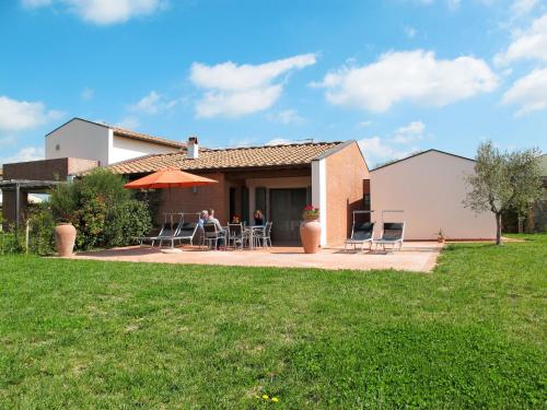 a couple sitting at a table outside of a house at Holiday Home Casa Fitzy by Interhome in San Donato in Poggio