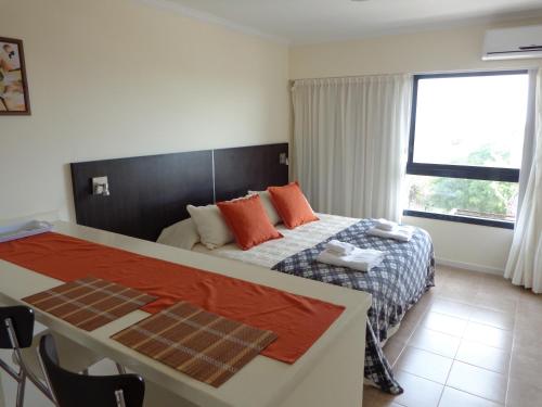 a bedroom with a bed and a large window at Rio Manso Apart Hotel in Victoria