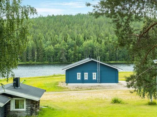 a blue house on the shore of a lake at Holiday Home Lakka by Interhome in Sonka