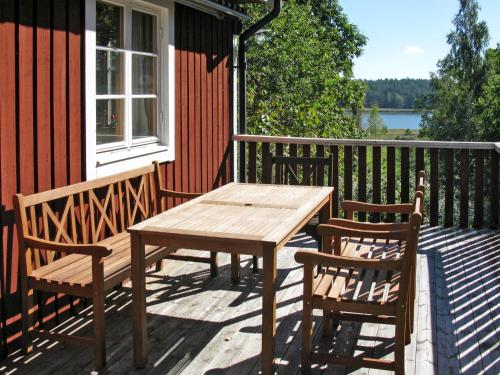 een houten tafel en twee stoelen op een terras bij Holiday Home Järnemåla Margaretetorp by Interhome in Valdemarsvik