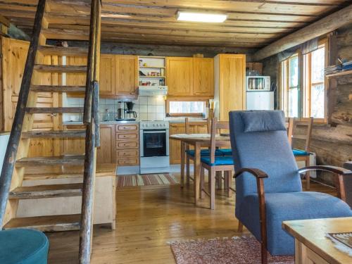 a kitchen with a spiral staircase in a log cabin at Holiday Home Ukkohermanni by Interhome in Luosto