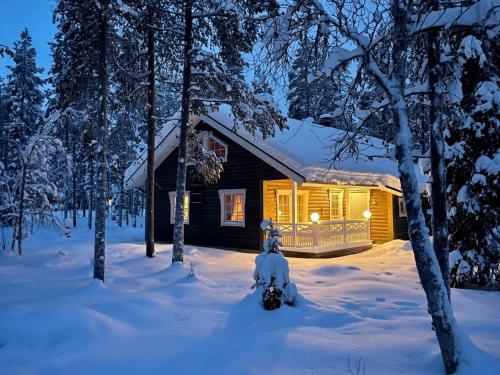 a cabin in the woods with snow on the ground at Holiday Home Ylläsriekko - itätupa by Interhome in Ylläsjärvi