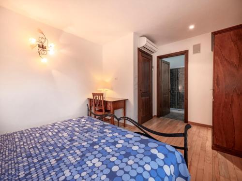 a bedroom with a bed and a table and a desk at Holiday Home Domus Magna-3 by Interhome in Povoletto