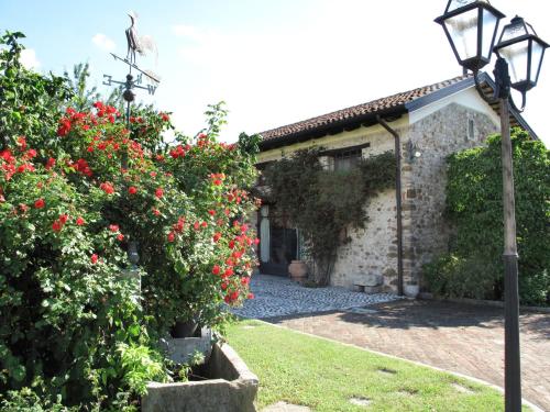 a house with red flowers and a street light at Holiday Home Domus Magna-2 by Interhome in Povoletto