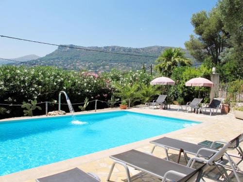 - une piscine avec des chaises et des parasols dans un complexe dans l'établissement Apartment Villa Vivendi - VEN109 by Interhome, à Vence