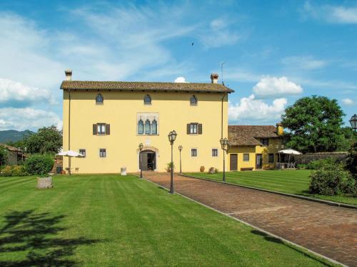 a large yellow house with a green lawn at Holiday Home Domus Magna-2 by Interhome in Povoletto
