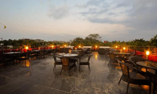 a group of tables and chairs on a patio at night at Hotel Jullundur 18 in Chandīgarh