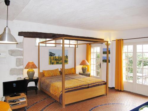 - une chambre avec un lit à baldaquin et des rideaux jaunes dans l'établissement Apartment Laurier by Interhome, à Vence