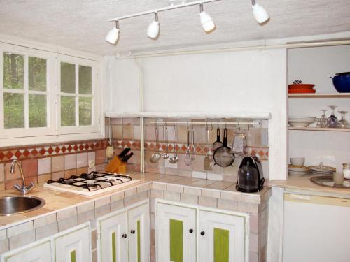 une cuisine avec des armoires blanches et un four à plaques de cuisson dans l'établissement Apartment Laurier by Interhome, à Vence