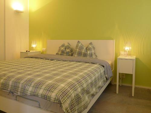 サンモリッツにあるチェーザ ラ ソリヴァのベッドルーム1室(ベッド1台、羽毛掛け布団、ナイトスタンド2台付)