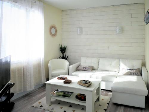 salon z białą kanapą i stołem w obiekcie Holiday Home Les Hirondelles - ADS185 by Interhome w mieście Andernos-les-Bains