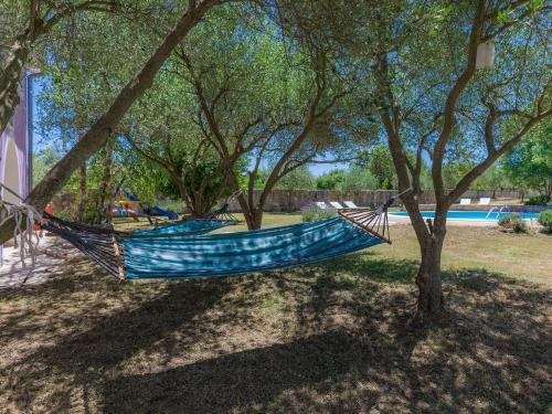 una hamaca azul colgando de un árbol en un parque en Villa Elda by Interhome, en Rakalj