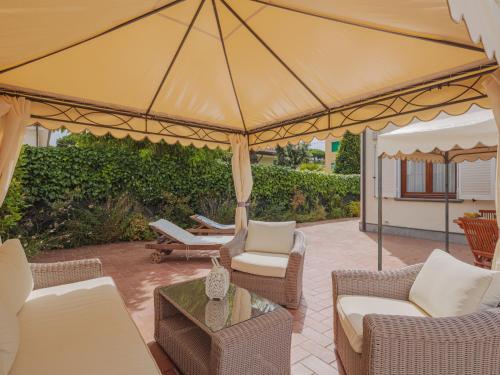 un patio con sedie e un grande ombrellone di Holiday Home Rosa by Interhome a Lido di Camaiore