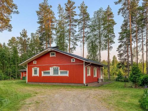 une maison rouge au milieu d'une forêt dans l'établissement Holiday Home Majavanpesä by Interhome, à Virtasaari
