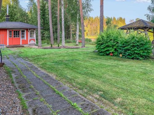 un jardin avec une maison rouge et un chemin dans l'établissement Holiday Home Majavanpesä by Interhome, à Virtasaari