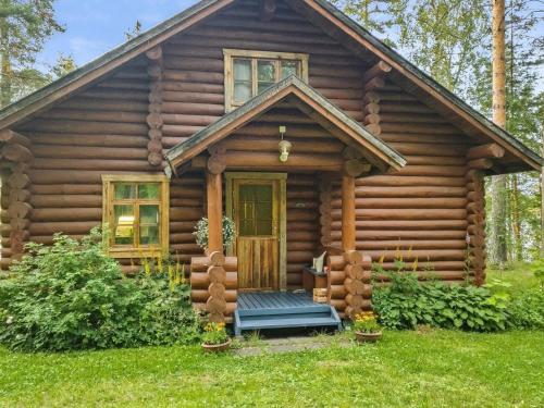 a log cabin with a porch and a door at Holiday Home Palkinniemi by Interhome in Putikko