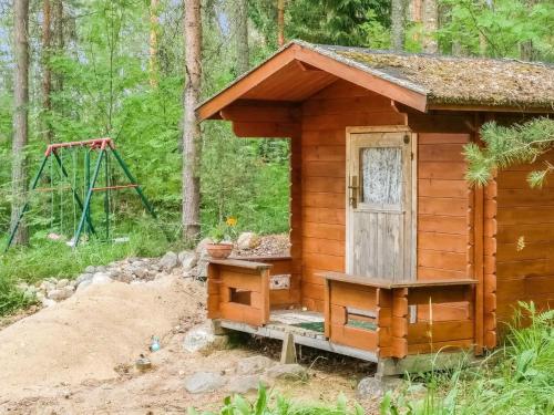 a small wooden cabin in the woods with a swing at Holiday Home Palkinniemi by Interhome in Putikko