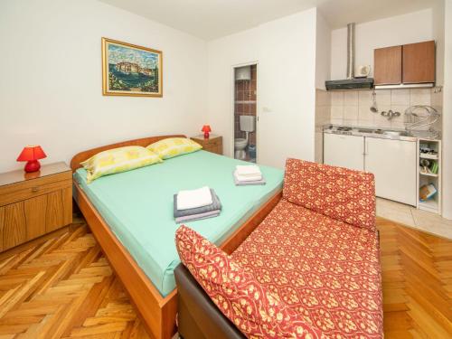 ein kleines Schlafzimmer mit einem Bett und einem Stuhl in der Unterkunft Apartment Jelka-1 by Interhome in Trstenik