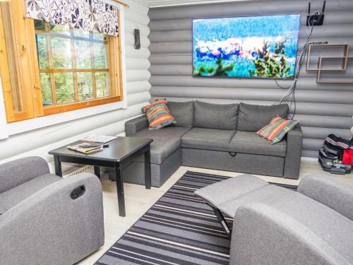 ein Wohnzimmer mit Sofa und Tisch in der Unterkunft Holiday Home Imponlampi by Interhome in Rukajärvi