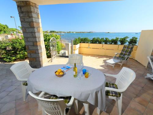 a table and chairs on a patio with a view of the ocean at Apartment Paola by Interhome in Cannigione