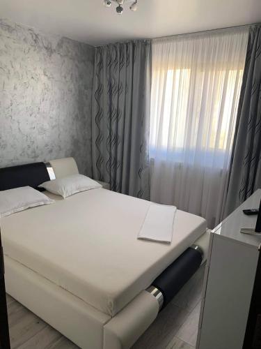 a white bed in a room with a window at ELEGANT & SILVER LUXURY Apartament in Craiova