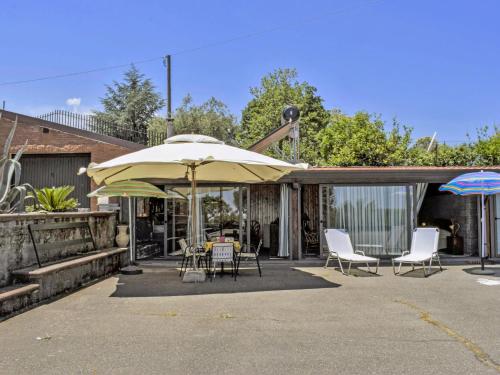 une terrasse avec une table, des chaises et un parasol dans l'établissement Studio Serena by Interhome, à Piedimonte Etneo