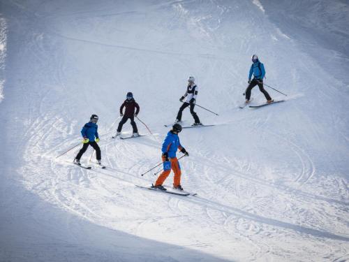 a group of people skiing down a snow covered slope at Apartment T-Resort La Tzoumaz 3p6 vue vallée by Interhome in La Tzoumaz