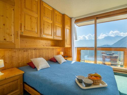 a bedroom with a bed with a bowl of fruit on a tray at Apartment Soyouz Vanguard-87 by Interhome in Le Corbier