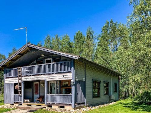 a green and white house with a porch at Holiday Home Niittyranta by Interhome in Kukko