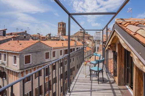 a balcony with chairs and a view of the city at Corte Rubbi 11 Secret Terrace Apartment in Venice