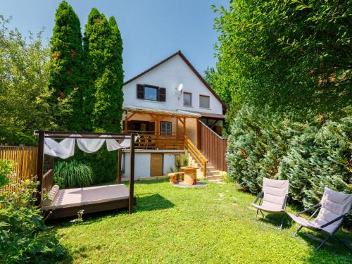 podwórze z dwoma krzesłami i domem w obiekcie Holiday Home Violetta Grande by Interhome w mieście Balatonkenese