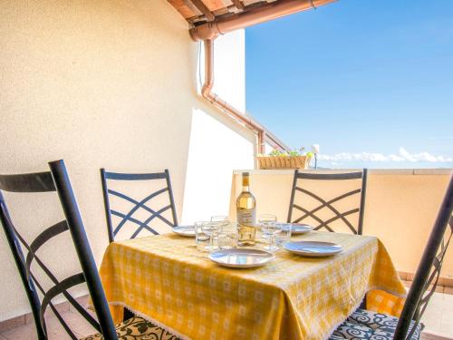 uma mesa com uma garrafa de vinho e copos em Apartment Poggio di Nocola-1 by Interhome em Riparbella