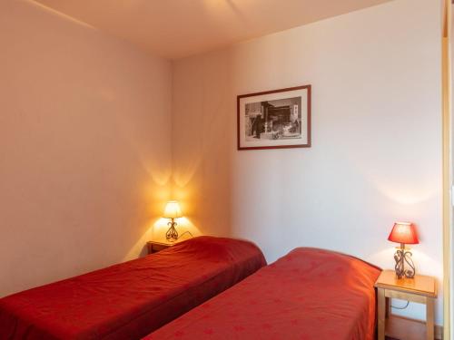 - une chambre avec 2 lits rouges et 2 lampes dans l'établissement Apartment Les Terrasses du Corbier by Interhome, au Corbier