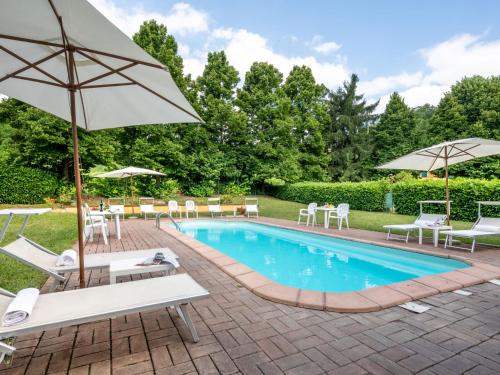 - une piscine avec des chaises longues et des parasols dans l'établissement Holiday Home Cascina Virginia-6 by Interhome, à Vigliano d'Asti