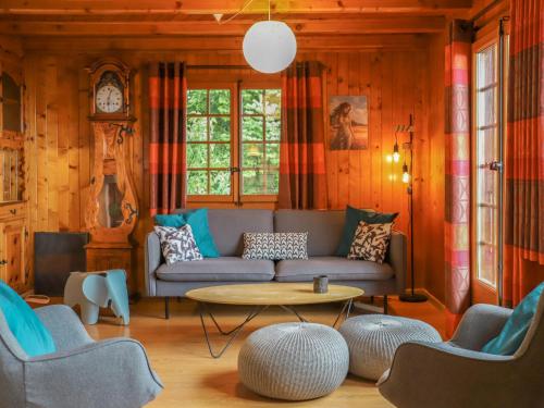 sala de estar con sofá, mesa y sillas en Chalet Les Rochers Blancs by Interhome en Chesières