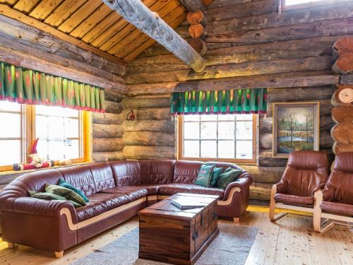 a living room with a leather couch in a log cabin at Holiday Home Terakka by Interhome in Sirkka