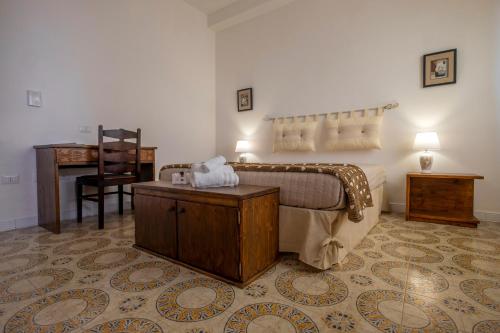 una camera con letto, scrivania e sedia di Hotel Soleo a Quartu SantʼElena