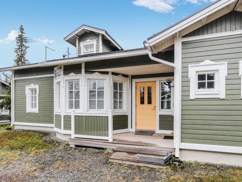 ein grünes Haus mit gelber Tür in der Unterkunft Holiday Home Rukan taikavuosselin helmi 8 b by Interhome in Ruka