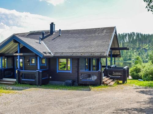 a small blue house with a porch at Holiday Home Nuppulanranta 14 by Interhome in Jämsä