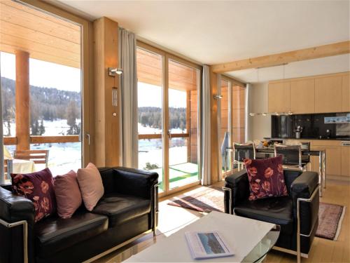 a living room with two leather couches and a kitchen at Apartment Chesa Lej by Interhome in Pontresina