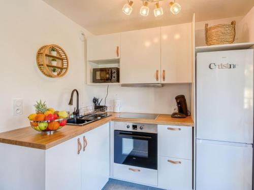 een keuken met witte kasten en een witte koelkast bij Apartment Paesu Pimpan by Interhome in Porto-Vecchio