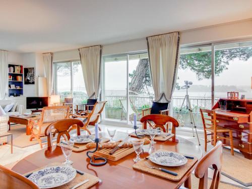 un salon avec une table, des chaises et des fenêtres dans l'établissement Apartment La Baie by Interhome, à Dinard