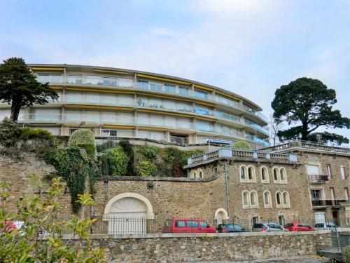 un bâtiment avec des voitures garées devant lui dans l'établissement Apartment La Baie by Interhome, à Dinard
