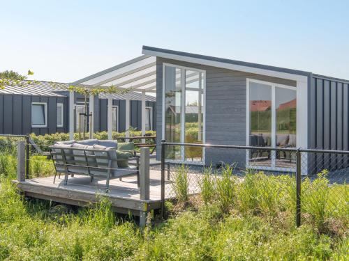 a tiny house with a bench on a deck at Holiday Home Ruisweg 83 by Interhome in Wemeldinge