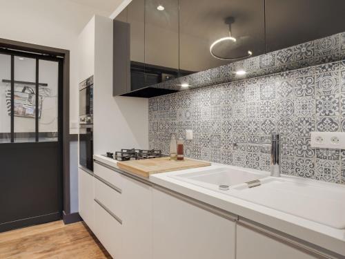- une cuisine avec un comptoir blanc et un évier dans l'établissement Apartment Ker Louis-1 by Interhome, à Dinard