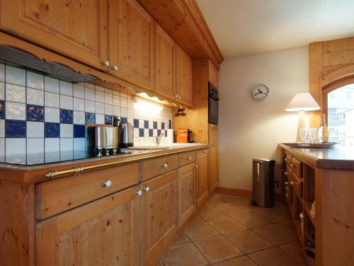 - une cuisine avec des placards en bois et un mur en carrelage dans l'établissement Apartment Villa Princesse by Interhome, à Chamonix-Mont-Blanc