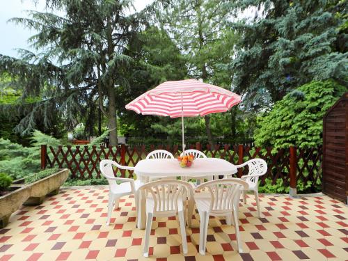 巴拉頓菲茲弗的住宿－Holiday Home Pinus 2 by Interhome，一张桌子,上面摆放着红色和白色的遮阳伞和椅子