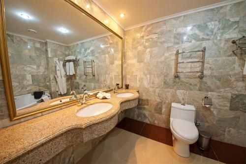 y baño con 2 lavabos, aseo y espejo. en Spa Resort Vnukovo, en Vnukovo