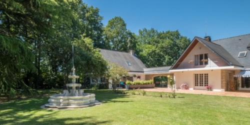 une maison avec une fontaine dans la cour dans l'établissement La Clotière, à La Guerche-de-Bretagne
